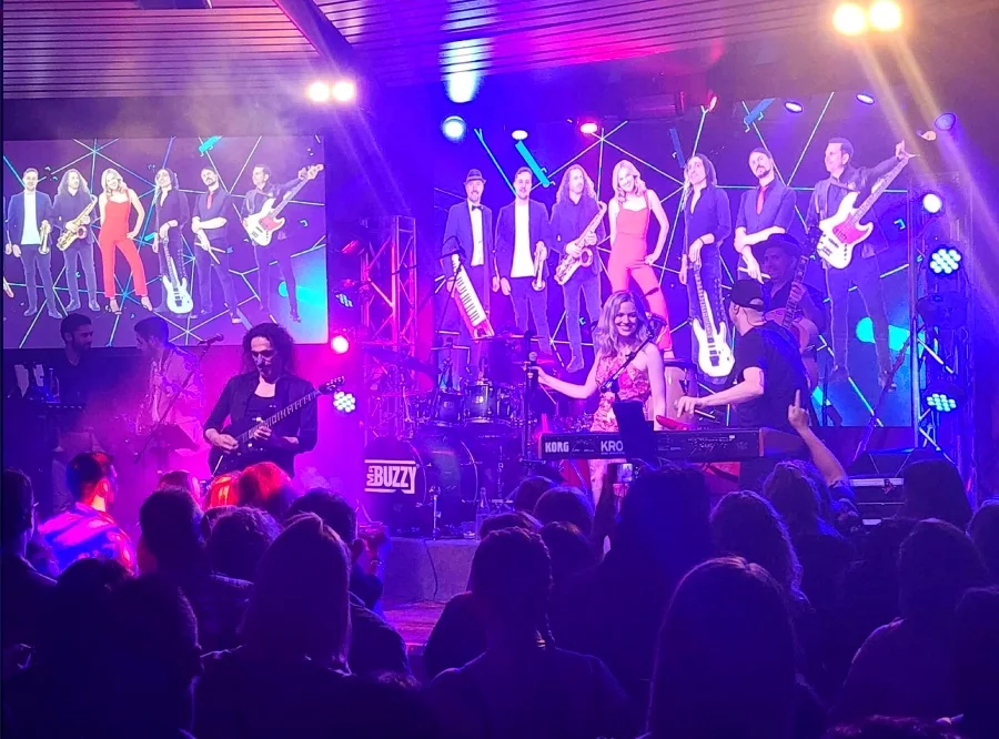 Full band on stage in purple light