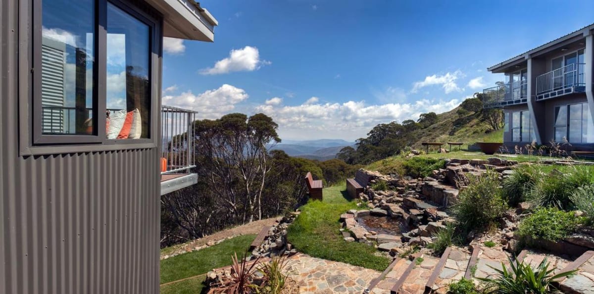 The General apartments building with private balconies and a rock garden, mountains beyond