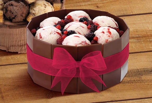 A Wendy's ice cream cake topped with berries and finished with a ribbon